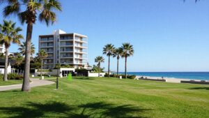 Luxury apartment balcony with park and ocean view.