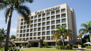 Oaks Mackay hotel exterior with palm trees.