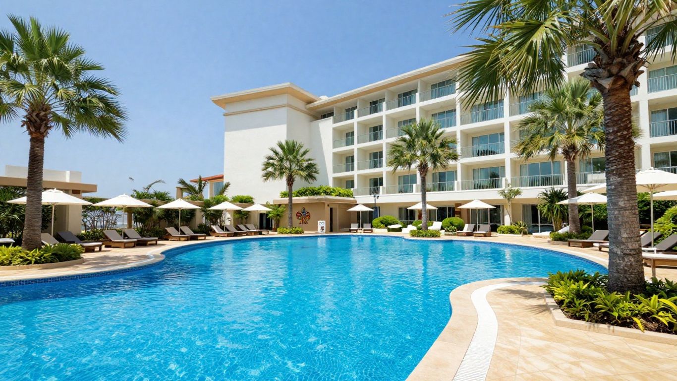 Oaks Mackay Stays pool with palm trees and hotel building.