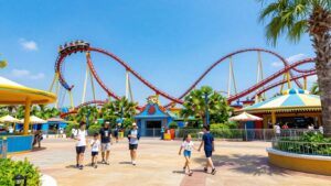 Theme park with roller coasters and happy families.